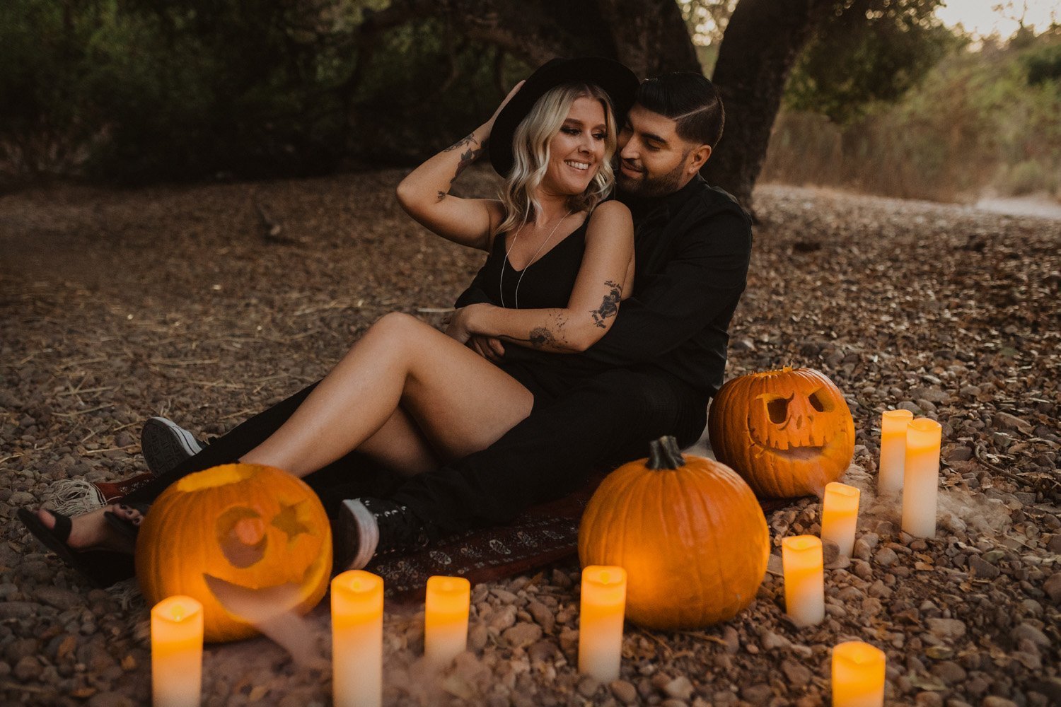 Couple cuddling and laughing at their Halloween themed San Diego engagement shoot