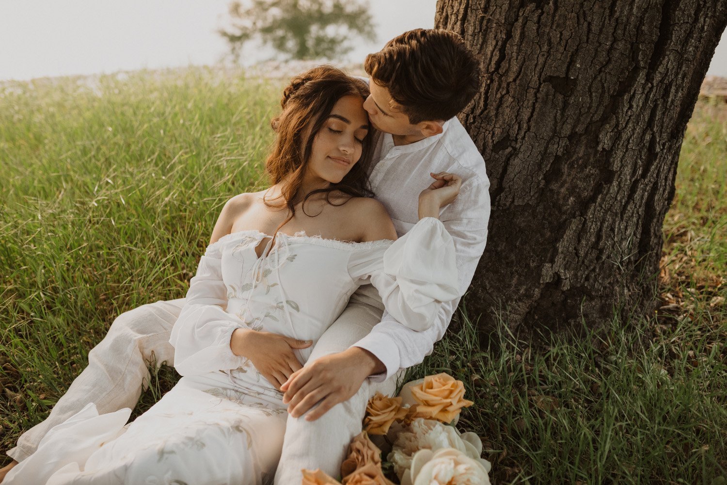 Bride and groom cuddling in the grass at their Milagro Winery wedding