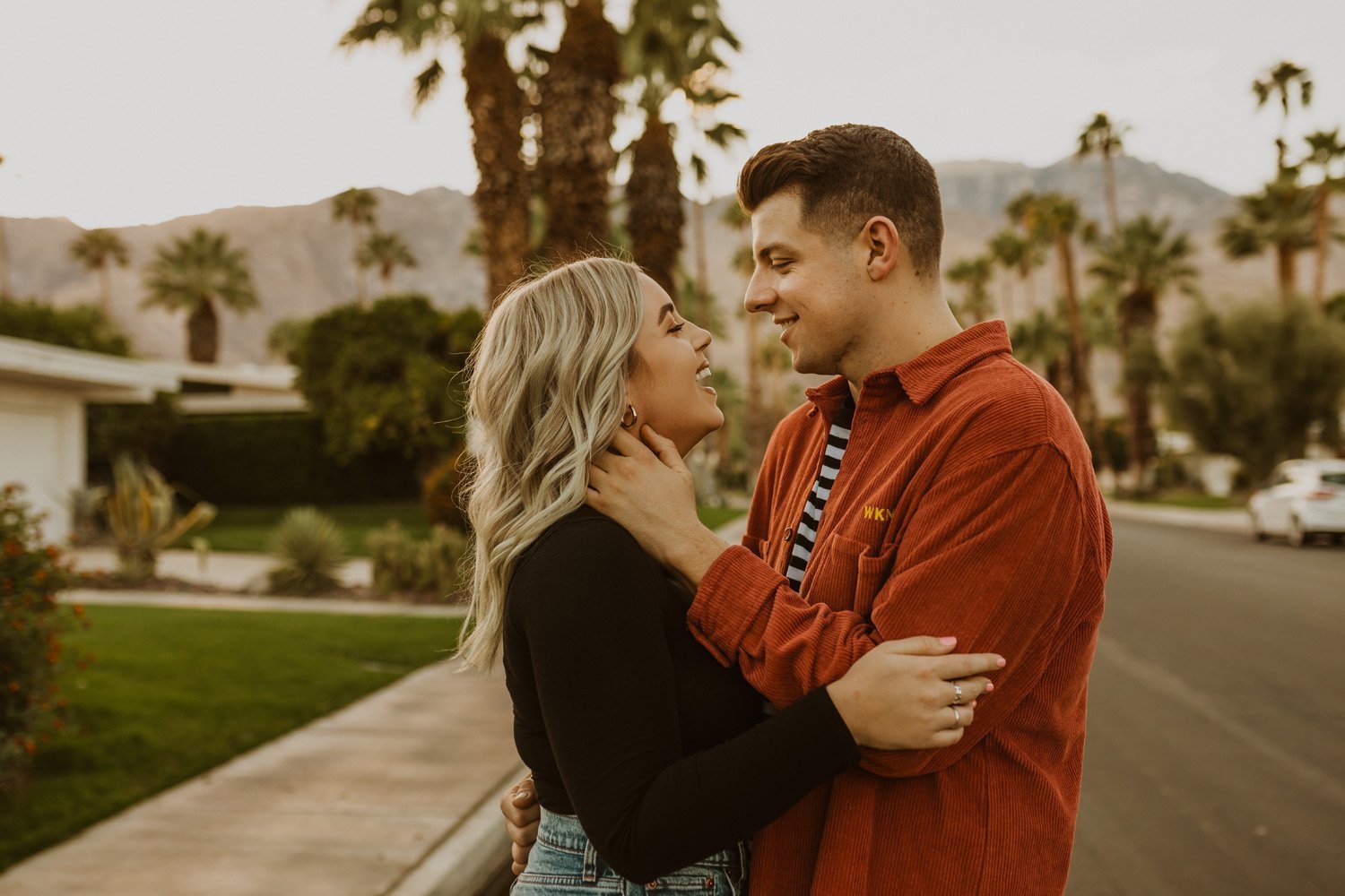 Couple laughing and hugging at their Palm Springs engagement session.
